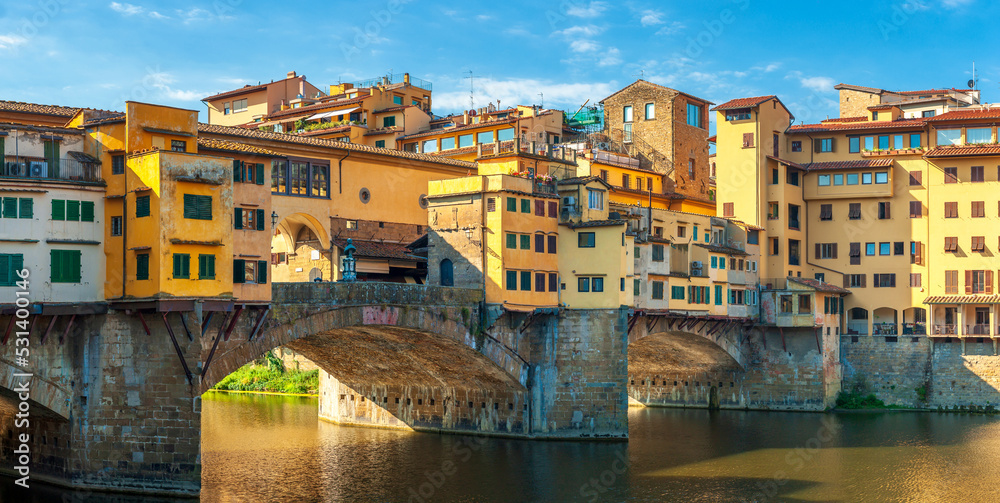 Panorama of beautiful medieval bridge Ponte Vecchio over Arno River, Florence, Italy. Architecture and landmark of Florence. Travel concept background.