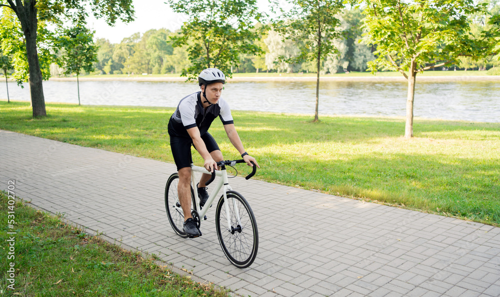 A male cyclist in a helmet rides a bicycle, training in the city. A male cyclist in a helmet rides a bicycle, training in the city.