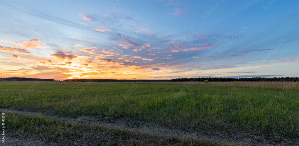 Epic sunset. Rural landscape with colorful clouds and sun on the horizon.