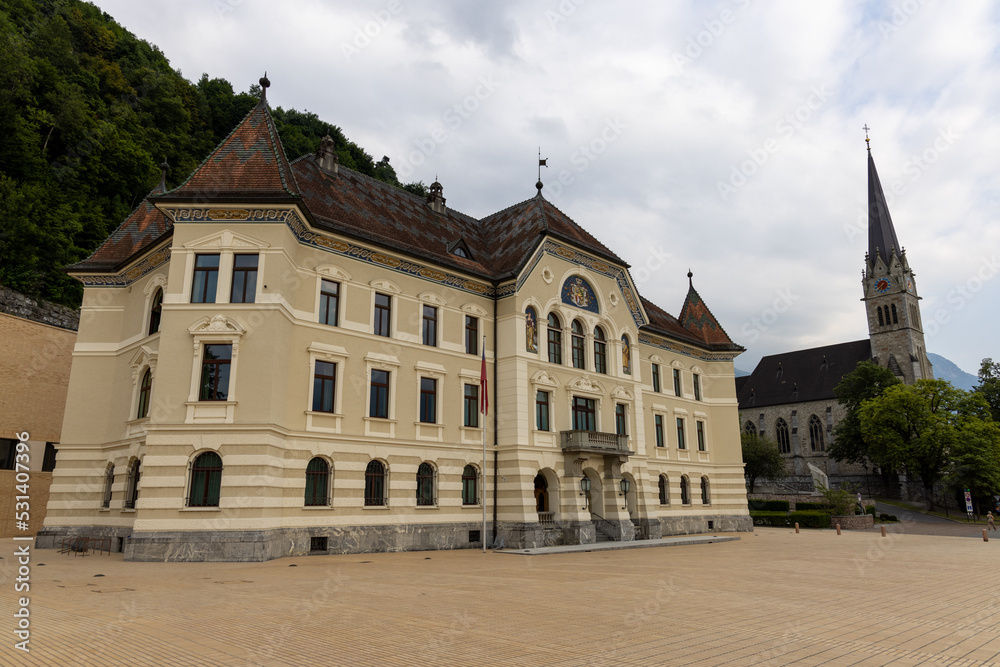 Government building of Liechtenstein on the Peter Kaiser Platz square in Vaduz with the cathedral of St. Florin in the background