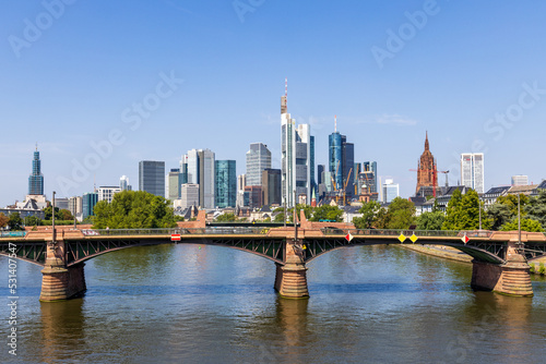 Frankfurt skyline and Ignatz Bubis bridge at daytime with the Main river in the foreground, taken from the Flösserbrücke bridge photo