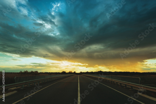Empty highway at sunset, clouds, rays of the sun © pobaralia
