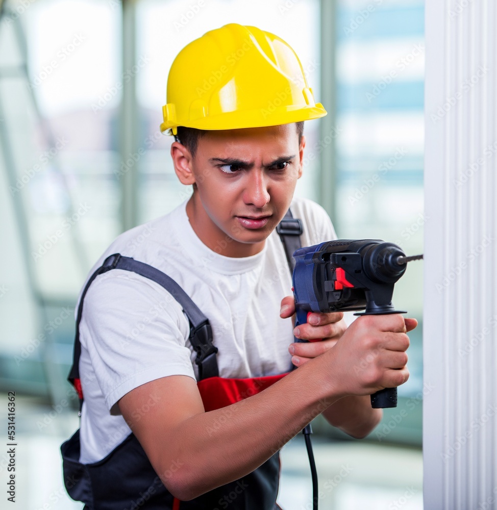Man drilling the wall with drill perforator
