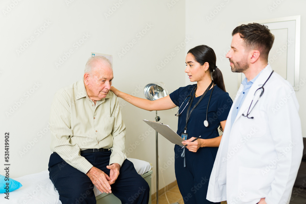 Obraz premium Doctor and nurse giving a medical treatment to an old man