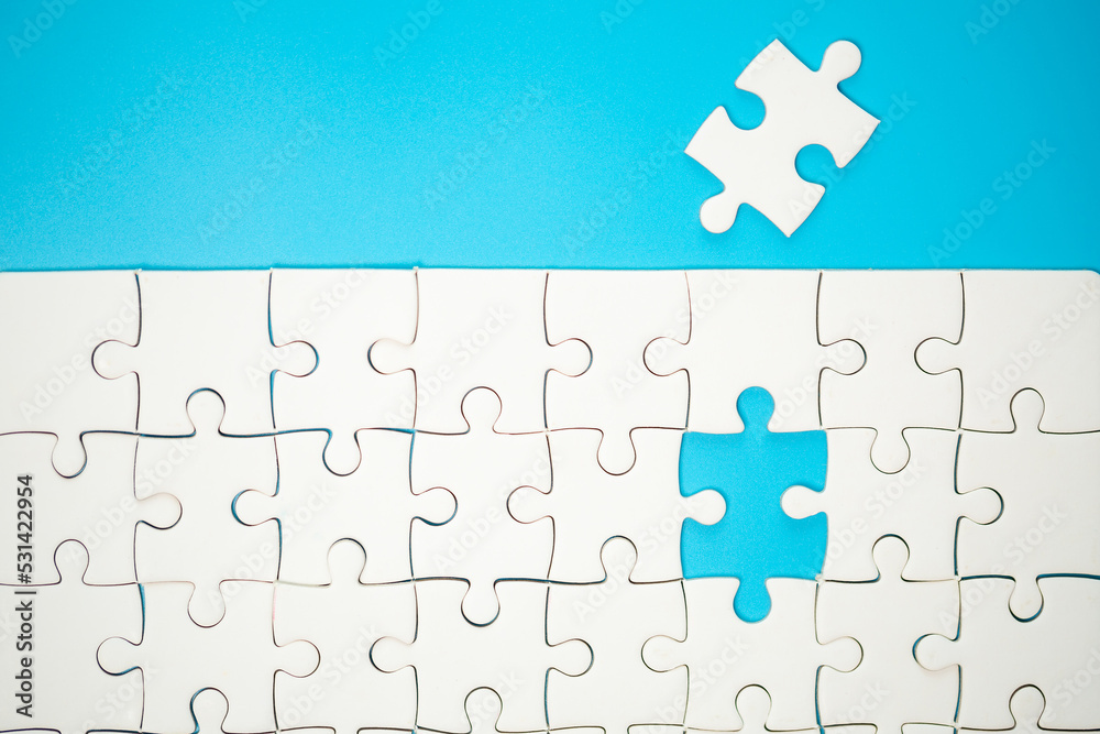 White part of jigsaw puzzle pieces on blue background. concepts of problem solving, business success, teamwork, Team playing jigsaw game incomplete, Texture photo with copy space for text White part of jigsaw puzzle pieces on blue background. concepts of problem solving, business success, teamwork, Team playing jigsaw game incomplete, Texture photo with copy space for text