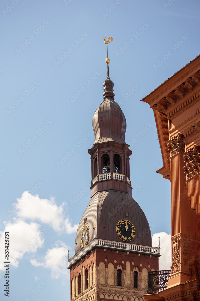 Obraz premium A church with a brown wall and a pointed metal tip in the middle of the city center