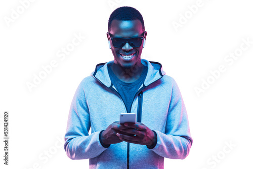 Portrait of young african american man using phone to listen music with earphones © Damir Khabirov