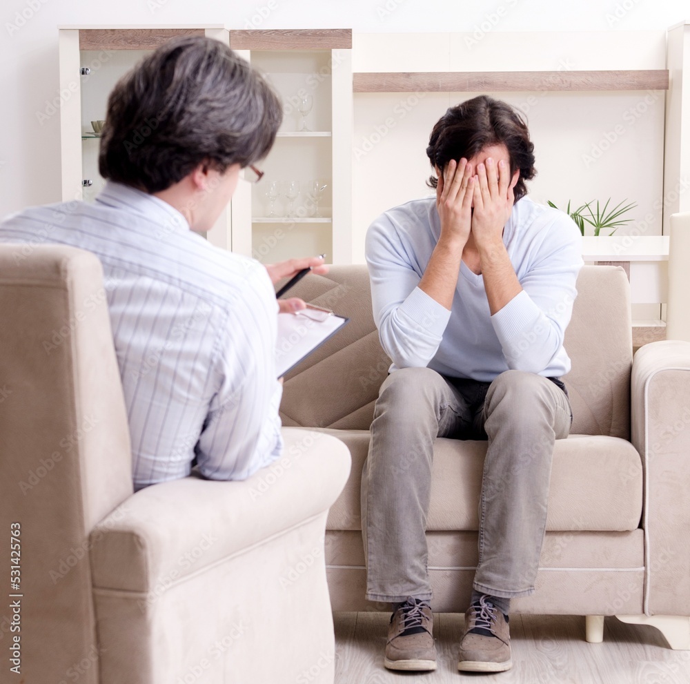 Young male patient discussing with psychologist personal problem Young male patient discussing with psychologist personal problem