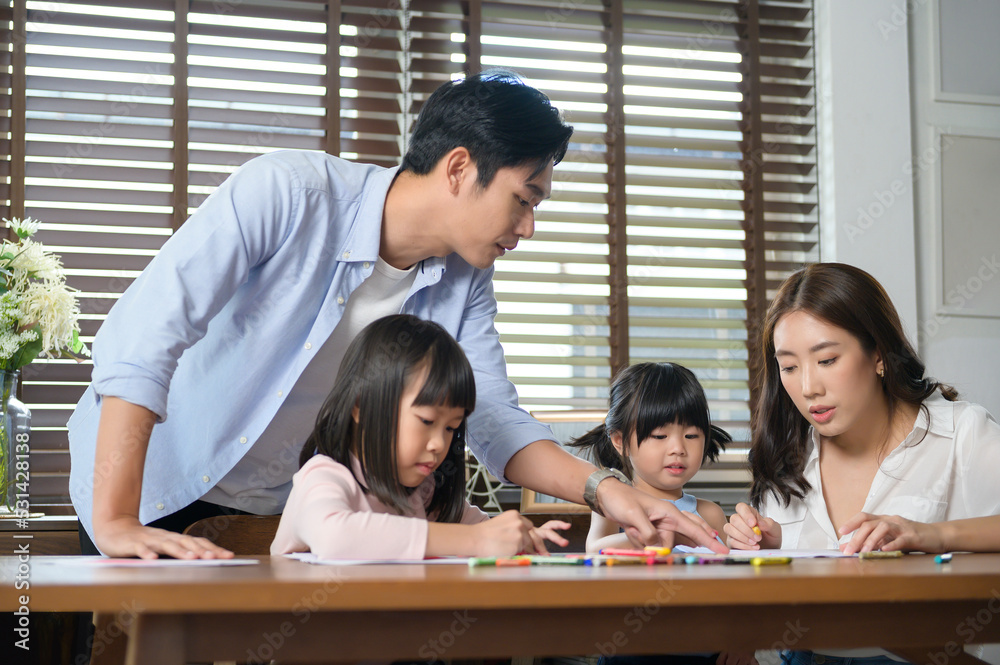 Asian family with children Drawing and painting on table in playing room at home, Educational game. Asian family with children Drawing and painting on table in playing room at home, Educational game.