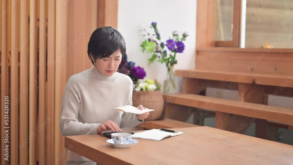  通帳を見ながら家計の予算が足りなくて頭を抱える人