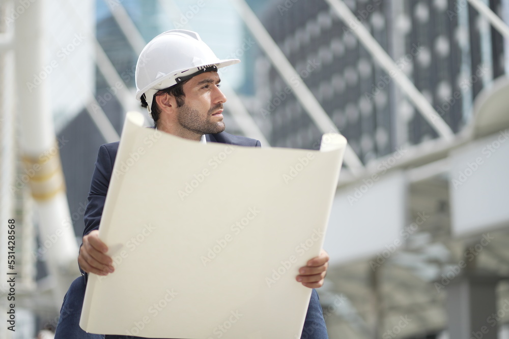 Architect or engineer with blueprints. Cauacsian Engineer checking plan on construction site. modern structure. Architect or engineer with blueprints. Cauacsian Engineer checking plan on construction site. modern structure.