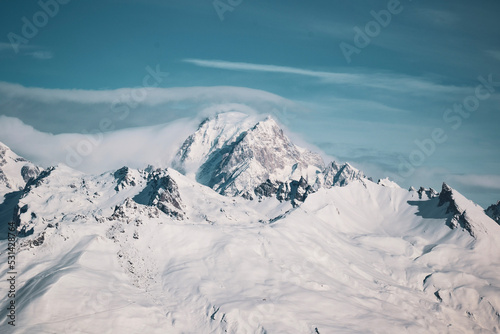 Mont-Blanc covered in snow overflown by a cloud