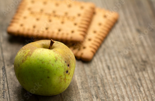 Apple and biscuits on a wooden table