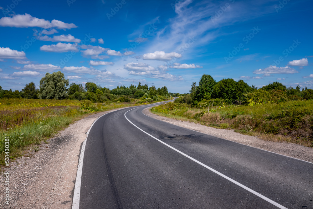 Picturesque asphalt road, beautiful summer view, Pskov region, Russia Picturesque asphalt road, beautiful summer view, Pskov region, Russia