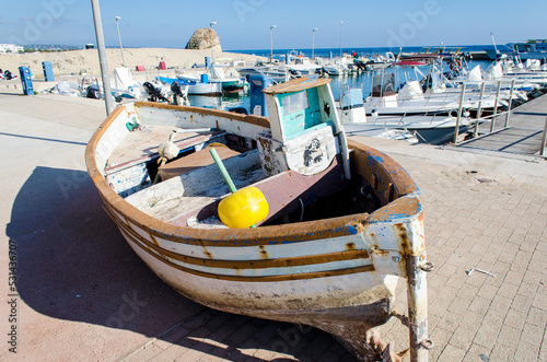 Una piccola barca tirata in secca sulla banchina del porto di Torre Pali nelle vicinanze di Salve in Salento photo