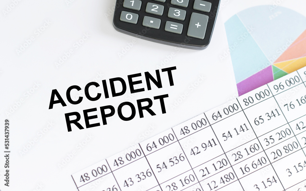 Business and finance. On the table are reports, charts, a notebook with the inscription - Accident report Business and finance. On the table are reports, charts, a notebook with the inscription - Accident report