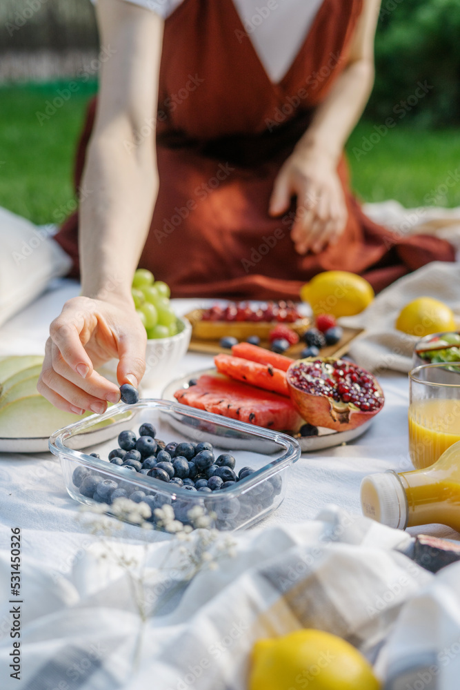 woman eat fruits and berry on picnic outdoors