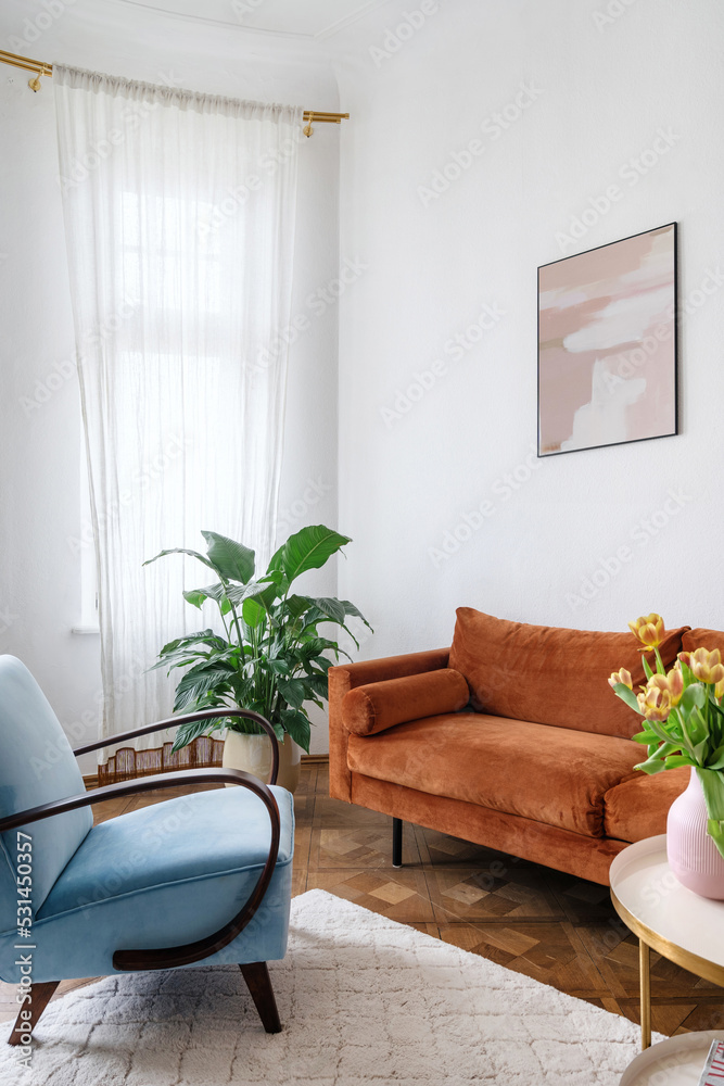 Bright living room in apartment with orange couch light blue