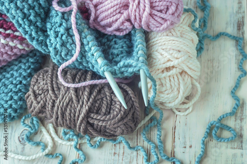 Skeins of thread and knitting needles on wooden background, selective focus.