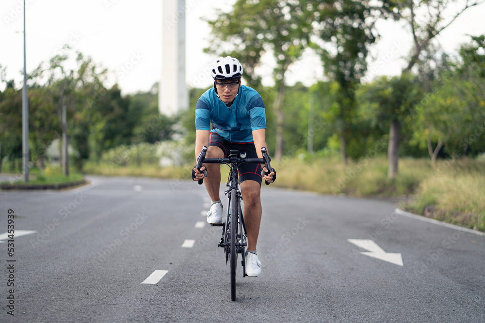 Asian man Cyclist Riding On Road Bike In City Park. Asian man Cyclist Riding On Road Bike In City Park.