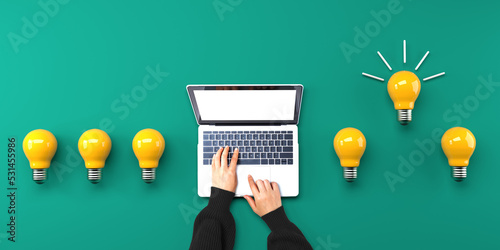Idea light bulbs with person using a laptop computer from above