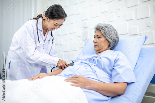 Fototapeta Naklejka Na Ścianę i Meble -  Beautiful asian doctor with stethoscope and document folder, examine the symptom for patient in the recovery room. Healthcare and medicine concept.