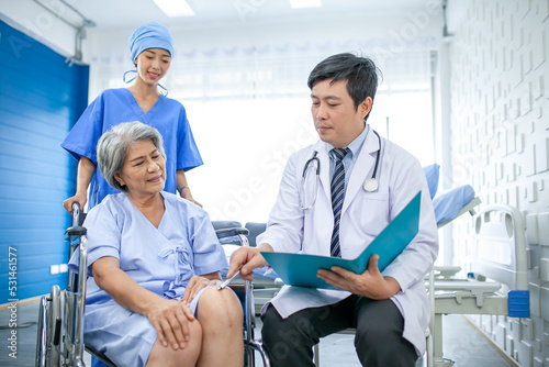 asian doctor with stethoscope and document folder, examine the symptom for senior patient in the recovery room. Healthcare and medicine concept.