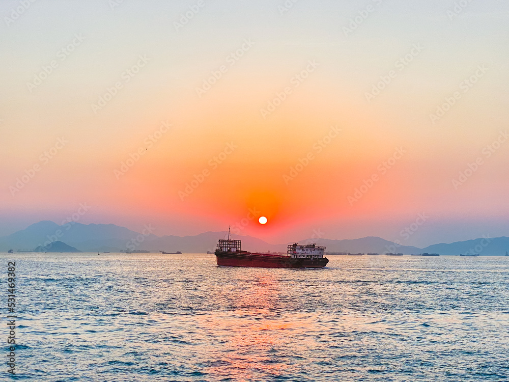 beautiful views of a ship passing with red gradient sunset | Victoria Harbour | West Kowloon Cultural District, Hong Kong