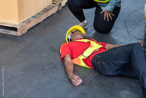 Warehouse worker lying down on floor after having accident from working in the factory. safety and protection for risky career