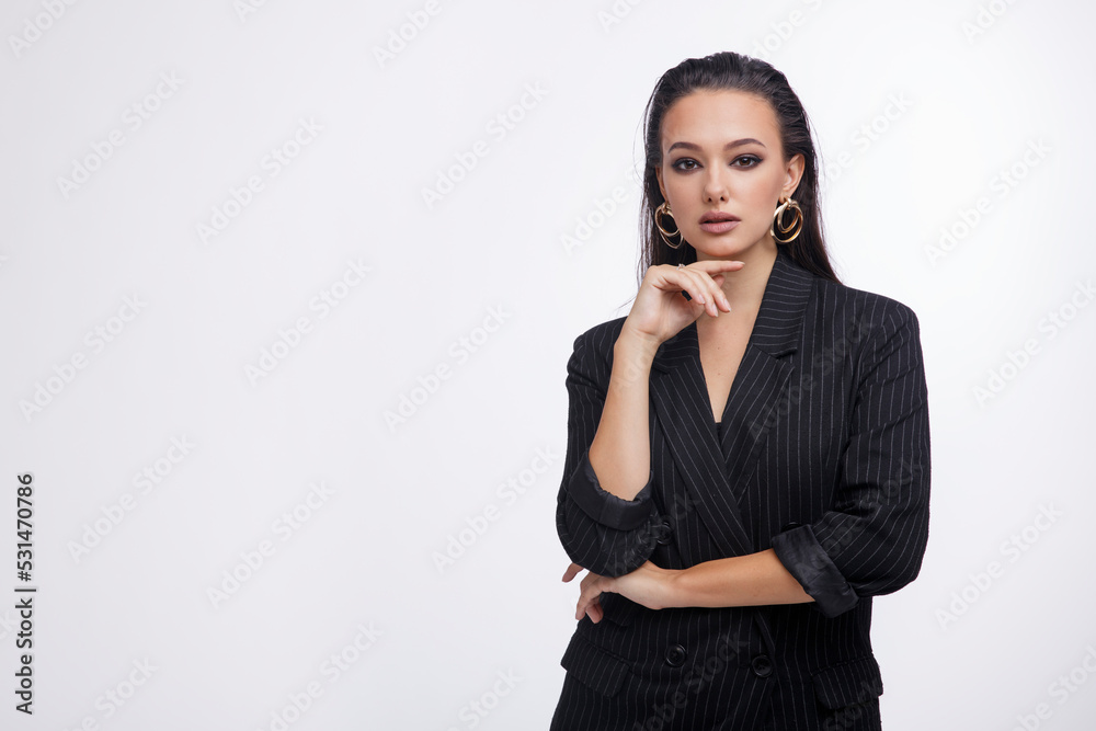 Fashion photo of a beautiful elegant young woman in a pretty black jacket, leather pants, boots, posing over white background. The hair is gathered back, dark brunette. Studio Shot Fashion photo of a beautiful elegant young woman in a pretty black jacket, leather pants, boots, posing over white background. The hair is gathered back, dark brunette. Studio Shot