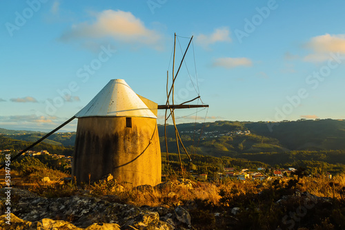 Lonely windmill at sunset, on a hill. Highlands in the evening sunset light