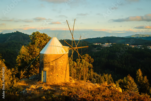 Lonely windmill at sunset, on a hill. Highlands in the evening light