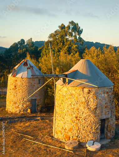Old ruined windmills in the sunset light. Mountain landscape in the evening