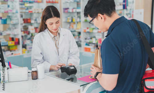 female pharmacist at drugstore.Health care pharmacists work at the hospital.Pharmacist looking at male customer.Doctor specialists organize prescription medications.The customer pay for medicines 