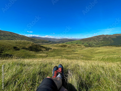 Hiking shoes. POV shot. Sitting in grass.