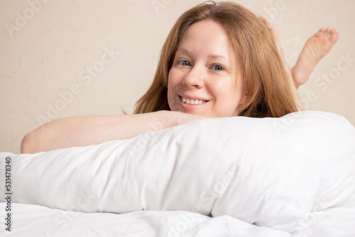 healthy sleep, a young woman lies in bed on a pillow, smiles, happy morning