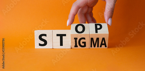 Stop and Stigma symbol. Concept words Stop and Stigma on wooden cubes. Beautiful orange background. Businessman hand. Business and Stop and Stigma concept. Copy space. photo