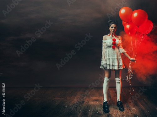 Fotótapéta Fantasy portrait woman clown holding red balloons in hands, creative drawing professional halloween holiday makeup body art