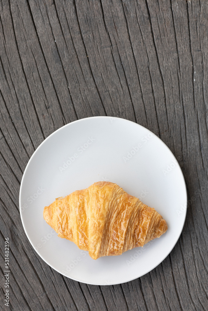 Fresh delicious breakfast morning with Coffee, food croissants on brunch plate, jam on dark grunge wooden background. continental breakfast captured on above table top view flat lay.