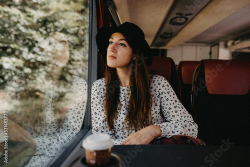 Young woman traveling on a train looking out of the window in thought © NoemiEscribano