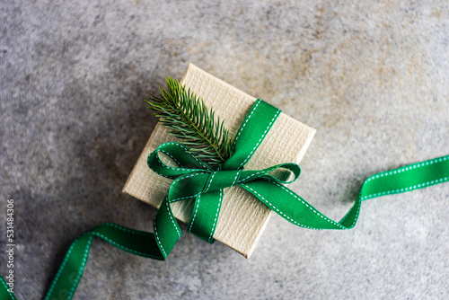 Overhead view of a rustic gift box tied with a ribbon and decorated with a fir branch photo