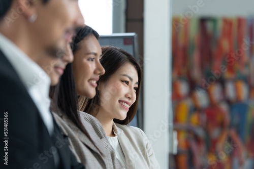 Foto Young asian woman freshman joined the group of young entrepreneurs with three seniors on the team