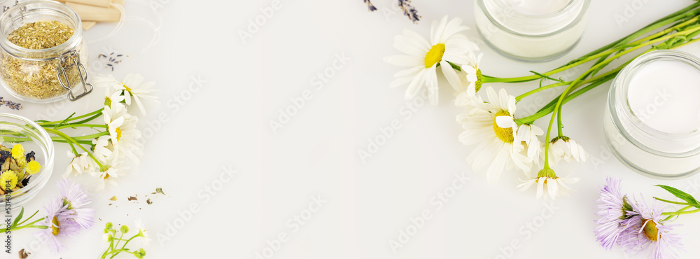 Natural products from wild plants and flowers. Eco friendly banner with natural flowers and herbs, tea bags, jars with cream on a white background with copy space. Banner size - obrazy, fototapety, plakaty 