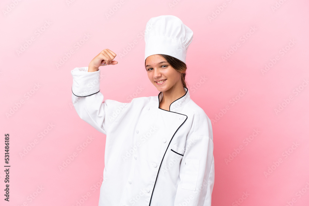 Little caucasian chef girl isolated on pink background doing strong gesture Little caucasian chef girl isolated on pink background doing strong gesture