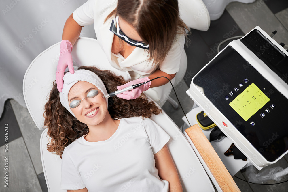 Top view of happy patient with protection for eyes who undergoing laser