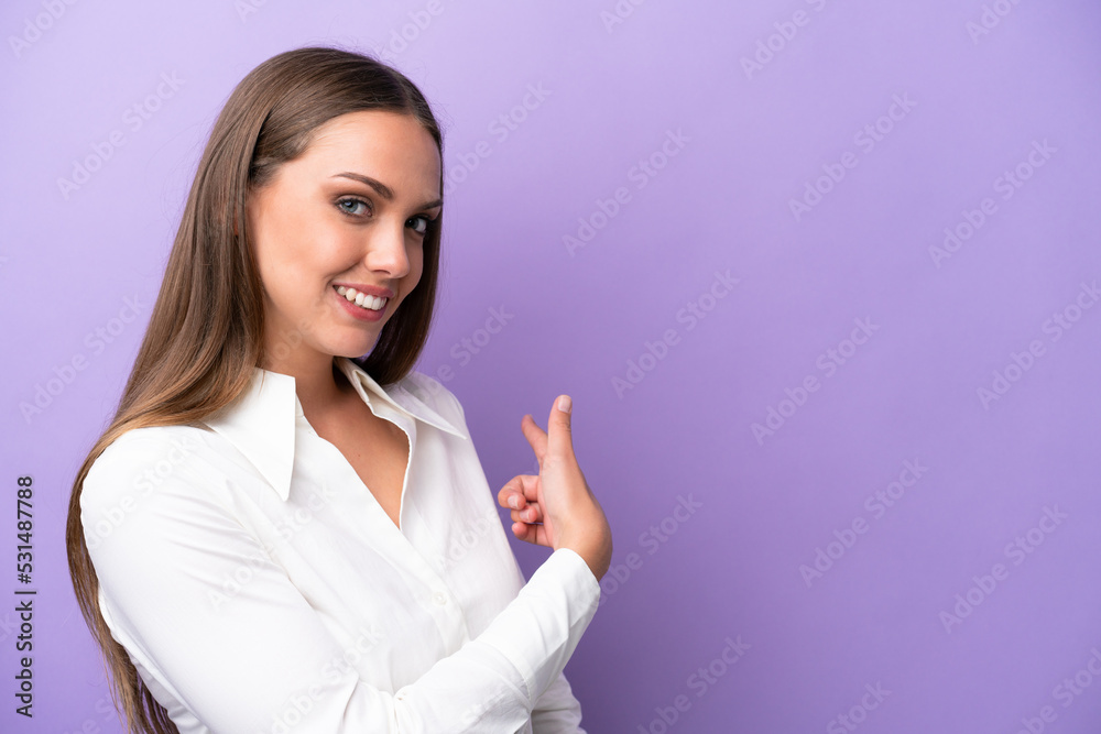 Young caucasian woman isolated on purple background pointing back Young caucasian woman isolated on purple background pointing back