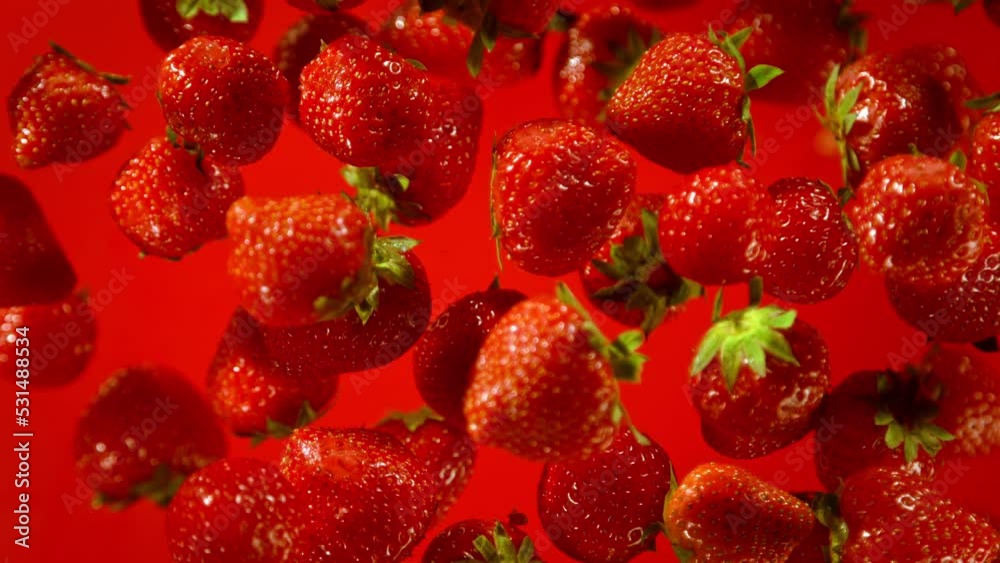 Super Slow Motion Shot of Fresh Strawberries on Red Background Flying Towards Camera at 1000fps.