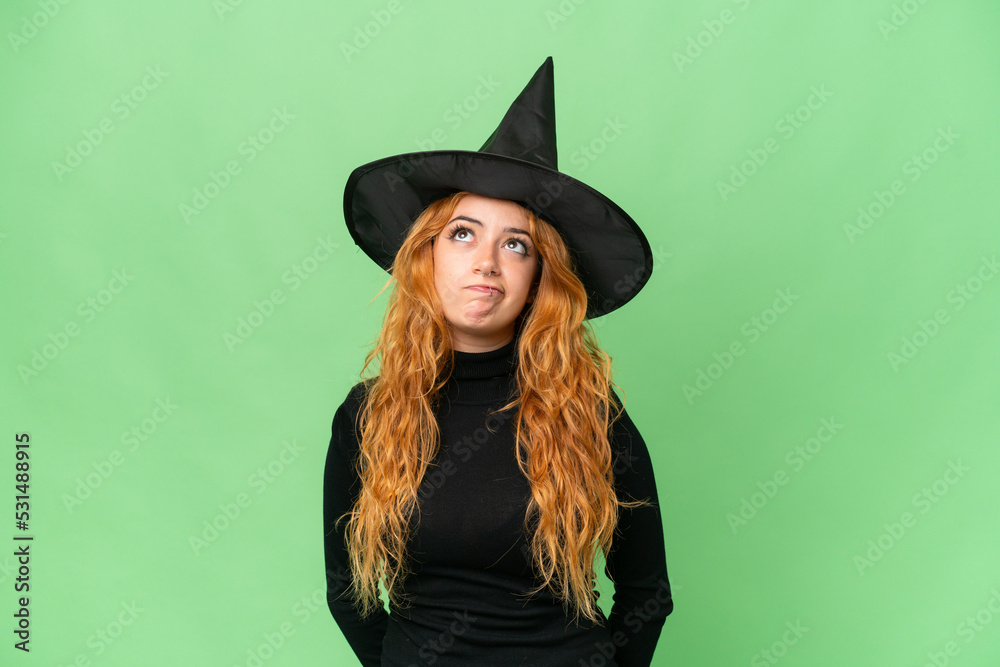 Young caucasian woman costume as witch isolated on green screen chroma key background and looking up Young caucasian woman costume as witch isolated on green screen chroma key background and looking up