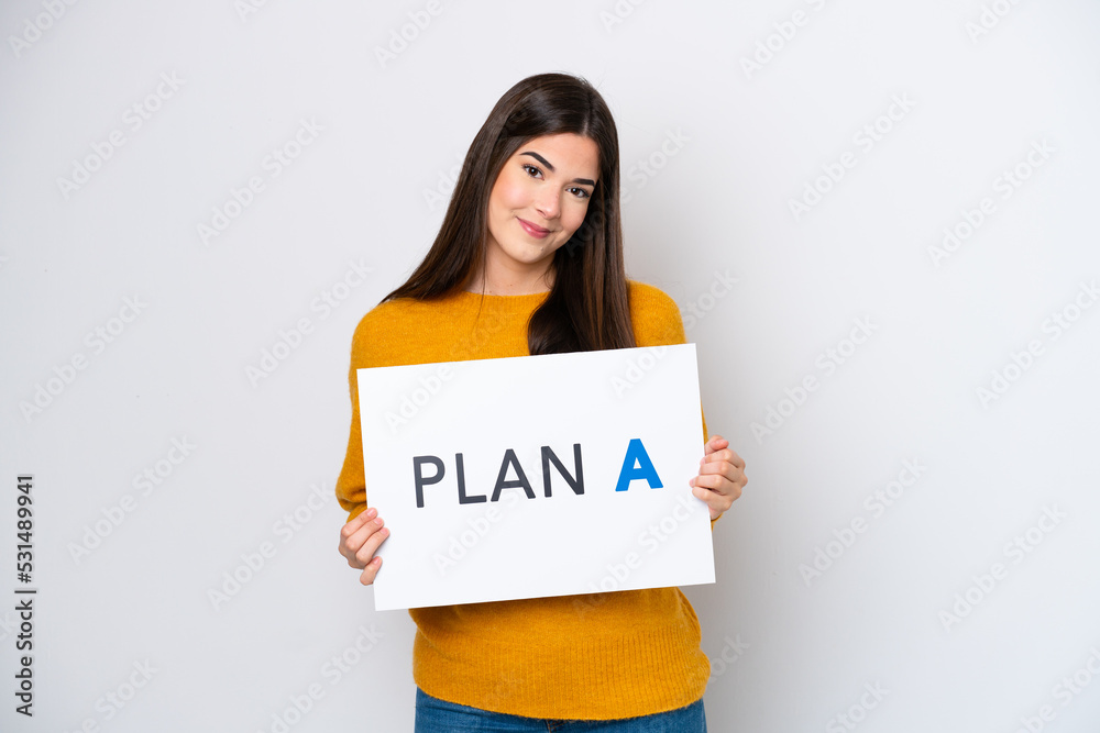 Young Brazilian woman isolated on white background holding a placard with the message PLAN A Young Brazilian woman isolated on white background holding a placard with the message PLAN A