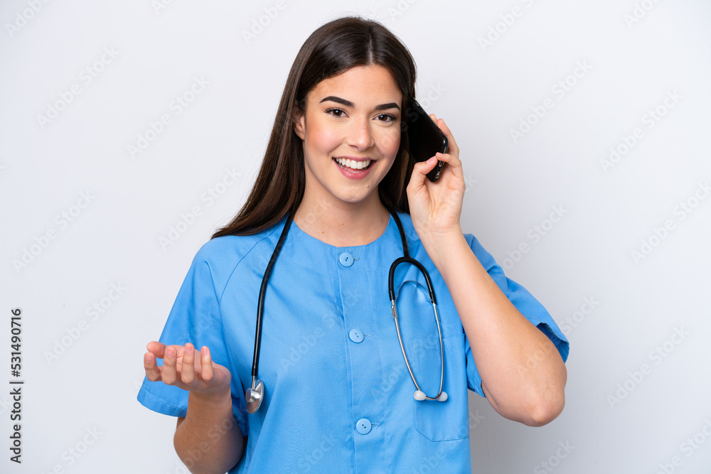 Young Brazilian nurse woman isolated on white background keeping a conversation with the mobile phone with someone